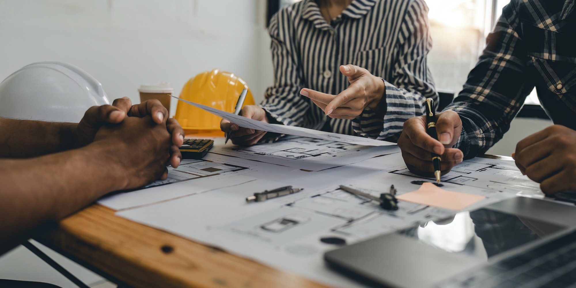 Architect and engineer team working with blueprints for architectural plan, engineer sketching a