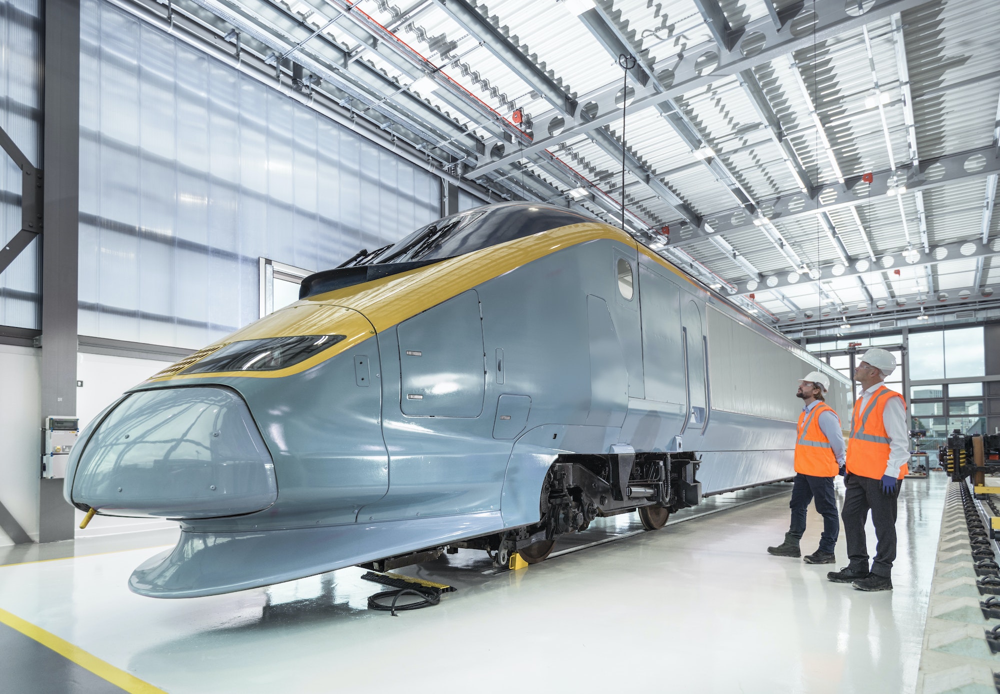 Engineers inspecting locomotive in railway engineering facility