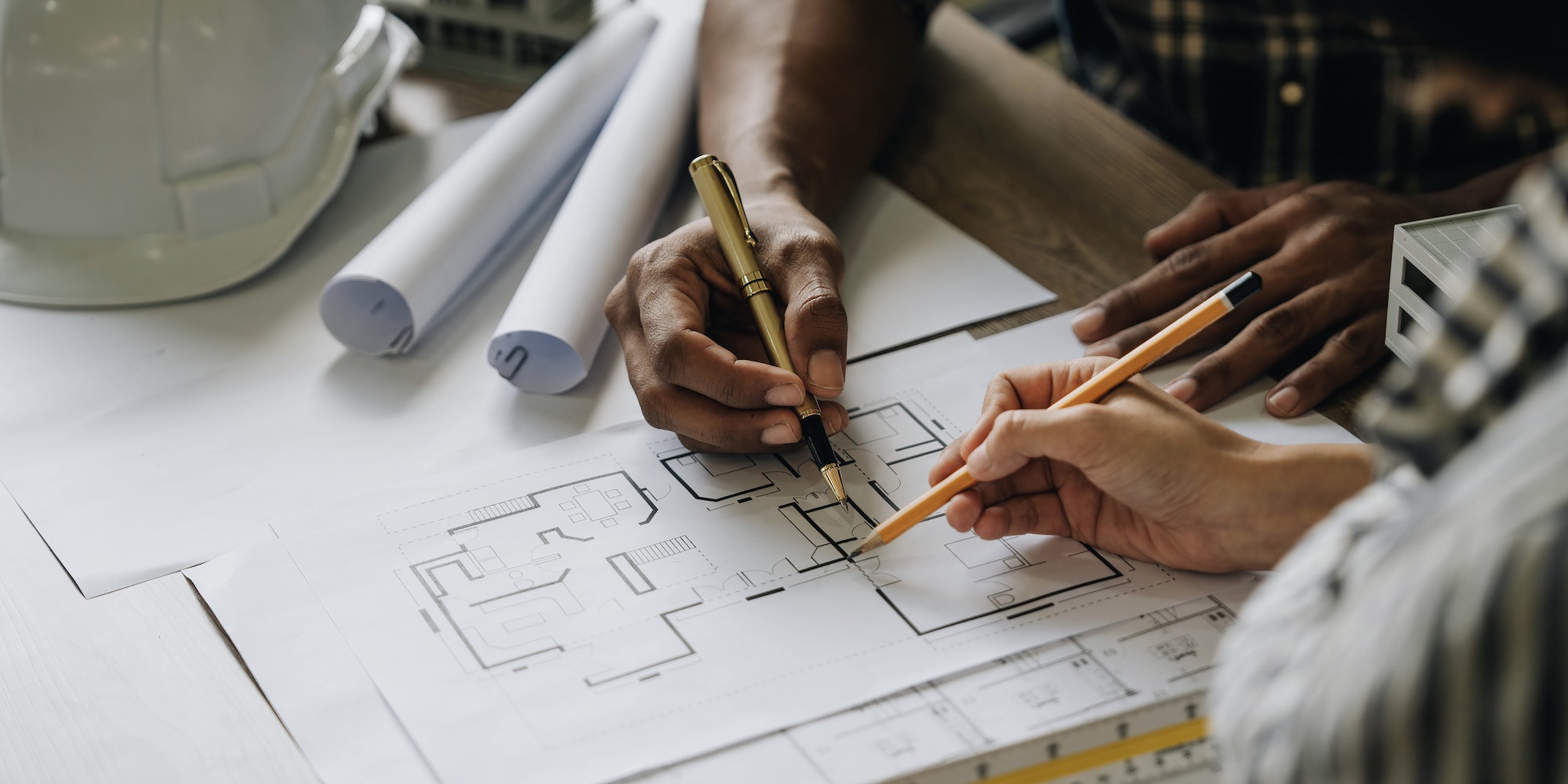 Team construction engineers working at construction site with blueprint on table